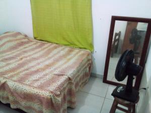 1 dormitorio con 1 cama con espejo y teléfono en Casa Do Junior Na Prainha Em Arraial Do Cabo, en Arraial do Cabo