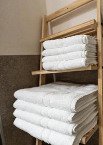 a stack of towels on a towel rack in a bathroom at Flow Apartments Kirchsteig in Merano