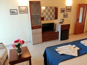 a bedroom with a bed and a tv and a couch at Moreno in Sozopol
