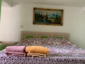 a pile of blankets on a bed with a picture on the wall at Syzo Rooftop 360° in Pogradec