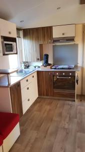 a kitchen with wooden cabinets and a counter top at mobil home zen in Valras-Plage