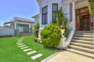 a house with a green lawn in front of it at Cape Diem Lodge in Cape Town