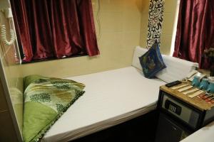 a small room with a bed and a window at Narli Guest House in Hong Kong