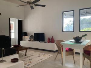 een woonkamer met een tafel en een tv bij Kasbah Andaluz guest house in Chiclana de la Frontera