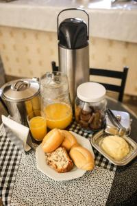 una mesa con un plato de pan y zumo de naranja en Pousada Rio Branco Nova Lima - By UP Hotel, en Nova Lima