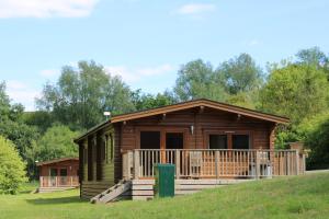 サマートンにあるViaduct Fishery Lodgesの草原の上の丸太小屋