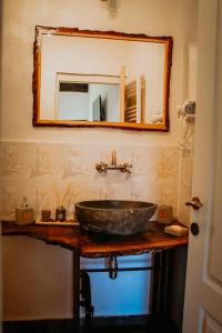 a bathroom with a stone sink and a mirror at Casa pe Valea Hartibaciului(Bărcuț) in Bărcuţ +110 photos