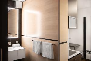 a bathroom with a sink and a toilet and a mirror at KU Hotel by WMM Hotels in Kulmbach