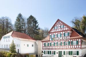 a large white building with a red roof at KU Hotel by WMM Hotels in Kulmbach