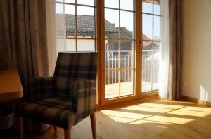 a person sitting on a chair in front of a window at Der Obere Wirt zum Queri in Andechs