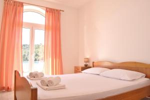 1 dormitorio con 1 cama con toallas en Mljet Sunset Apartments en Pomena