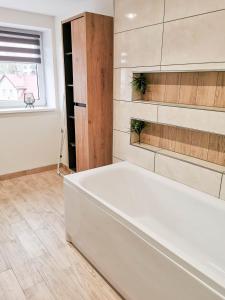 a white bath tub in a room with a window at U Szwagra in Ustka