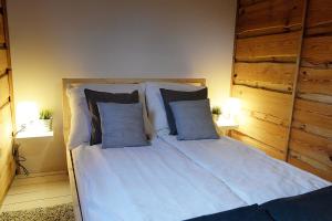 1 dormitorio con 1 cama con sábanas y almohadas blancas en Chatka w kratkę en Retowo