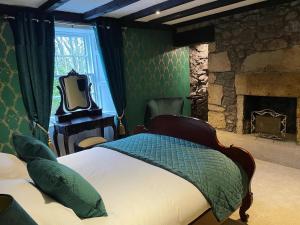 a bedroom with a bed and a stone fireplace at The Tormaukin in Glendevon