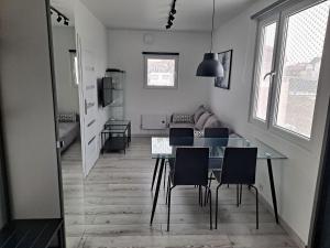 a dining room and living room with a table and chairs at Radosna Zatoka - Domki mobilne i drewniane z ogródkami, apartamenty, namioty in Międzywodzie