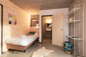 a bedroom with a bed in a wooden wall at Daft Hotel & Glamping in Malmedy +77 photos