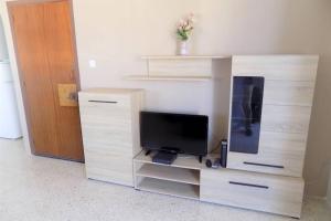 a wooden entertainment center with a flat screen tv at Sunshine Holiday Apartment 5 with Spectacular Seaviews in St. Paul's Bay