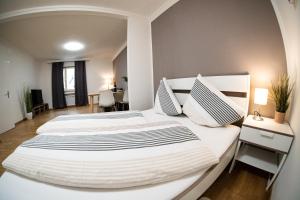 two white beds in a bedroom with a desk at Flow Apartments Kirchsteig in Merano