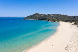 an aerial view of a beach with people on it at Cala Sinzias Resort in Castiadas