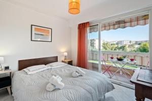 una camera con un letto e una grande finestra di Les Jasmins Apartment a Vallauris