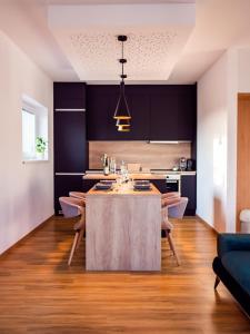 een keuken met zwarte kasten en een tafel met stoelen bij Apartman Eden in Rožnov pod Radhoštěm