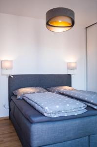 1 dormitorio con cama azul y luz en Apartman Eden, en Rožnov pod Radhoštěm