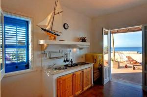 een keuken met een wastafel en uitzicht op de oceaan bij Apartment- Bilocale in Marettimo