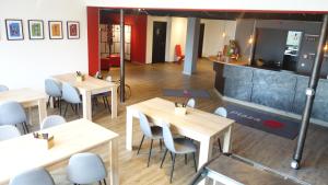ein Restaurant mit Tischen und Stühlen in einem Zimmer in der Unterkunft Plaza Inn Braunschweig City Nord in Braunschweig