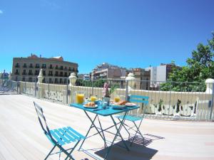 una mesa y sillas en un balcón con comida. en Canela Homes BARCELONA MARINA en Barcelona