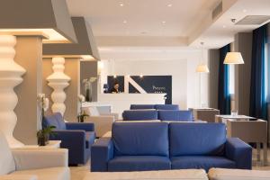 a lobby with blue couches and a waiting room at Atlantic Palace Hotel in Sorrento