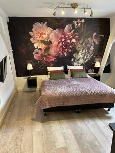 ein Schlafzimmer mit einem Bett mit einem Blumenbild an der Wand in der Unterkunft BnB Bruxelles in Venlo