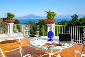 a table with a laptop on top of a balcony at Atlantic Palace Hotel in Sorrento