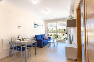 a kitchen and living room with a table and a blue couch at Melior-1 in Calpe