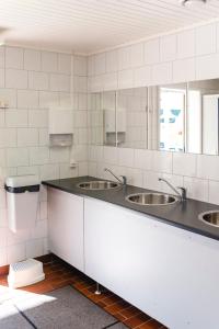 a bathroom with three sinks and two mirrors at Alevi Camping in Stöllet