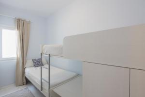 a white room with a bunk bed and a window at Cala Galdana Apartamentos El Rio in Cala Galdana