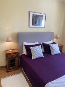 a bedroom with a purple bed with pillows at Casa Ayty in Carvoeiro