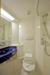 a bathroom with a sink and a toilet and a mirror at Hôtel de l'Océan in Notre-Dame-de-Monts