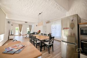 Una cocina y un comedor con una mesa y un refrigerador. en Villa Pepina, en Risika