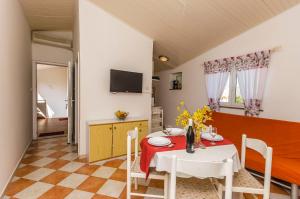 a dining room with a table and chairs and a tv at Apartments Manda in Vodice