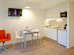 a kitchen with a table and chairs in a room at Apart-Suites Hostemplo in Barcelona
