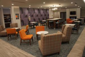 uma sala de espera com mesas e cadeiras e mesa em La Quinta Inn & Suites by Wyndham Littleton-Red Rocks em Littleton