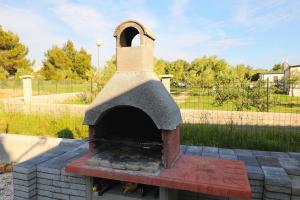 um forno de pizza sentado em cima de um pátio de tijolos em Mobile home Opal 1 em Biograd na Moru