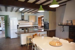 a kitchen with a table and a kitchen with white appliances at Impresionante Caserío Montañes del Siglo XVII in Entrambasaguas