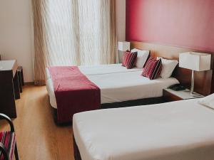 Postel nebo postele na pokoji v ubytování Hotel Coroa de Fátima