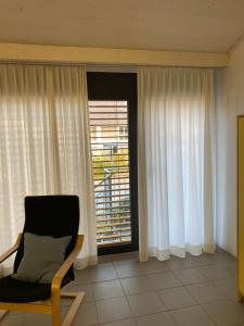 - un salon avec une chaise et une fenêtre dans l'établissement Bed and Breakfast Oase im Seetal, à Gelfingen