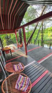 a porch with a hammock and chairs on a deck at VIP Red Love house for 2 in Shilagalyay