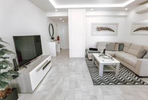 a living room with a couch and a tv at Apartment Rocha Vista Mar Dubai in Portimão