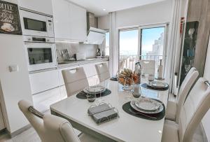a kitchen and dining room with a table and chairs at Apartment Rocha Vista Mar Dubai in Portimão