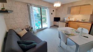 a living room with a couch and a table at LA BIGEONNIERE Appartement 1 chambre résidence avec piscine proche centre in Saint-Jean-de-Monts