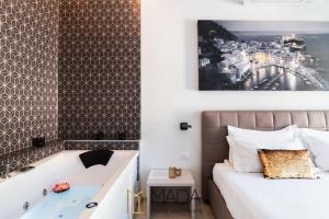 um quarto com uma cama, uma banheira e uma fotografia em MADA Charm Apartments Jacuzzi em Vernazza
